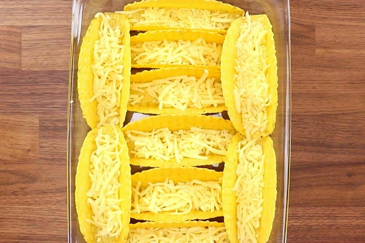 Arranged the taco shells in the dish and added cheese.