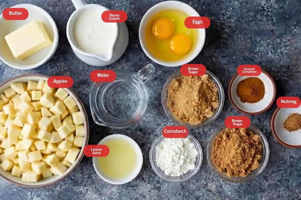 Flat lay photo of ingredient shot of butter, heavy cream ,eggs, apples, lemon juice, brown sugar, cornstarch, ground cinnamon, nutmeg, water