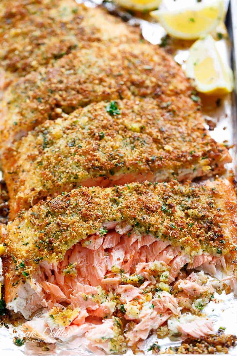 Tender fall apart oven baked salmon with a crispy parmesan crumb topping on a baking tray