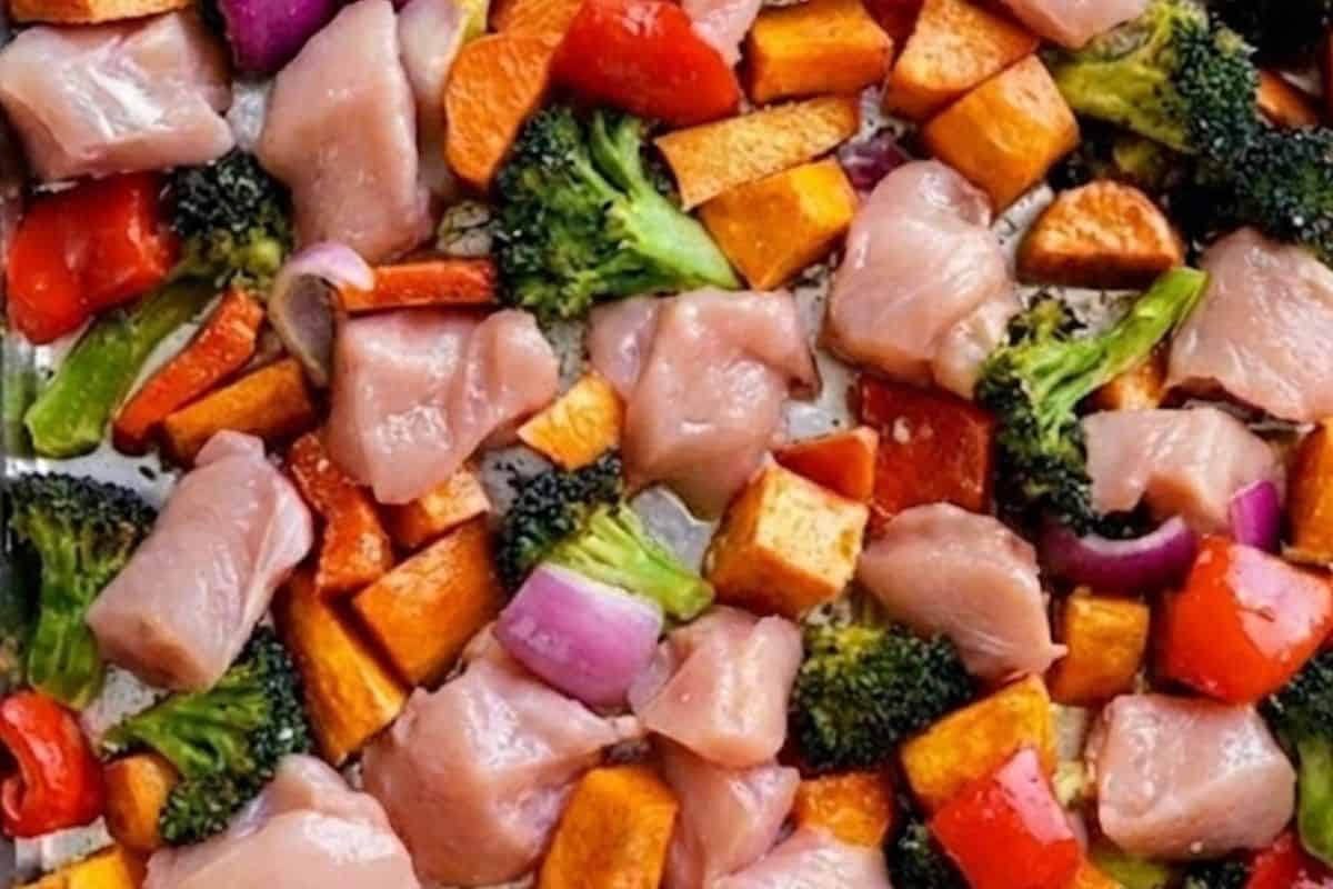 Remove the tray and arrange the chicken, broccoli, pepper, and onion around the sweet potatoes.