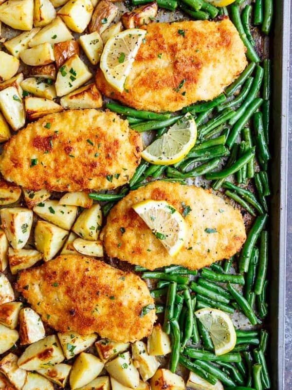 Oven baked and CRISPY breaded Sheet Pan Lemon Parmesan Garlic Chicken & Veggies, complete with potatoes and green beans smothered in a garlic butter sauce!
