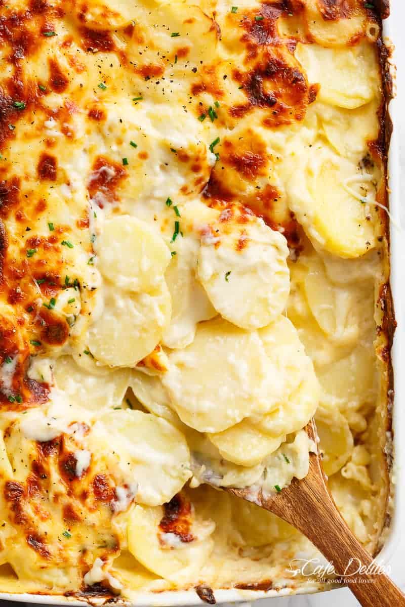 Garlic Parmesan Scalloped Potatoes layered in a creamy garlic sauce with parmesan and mozzarella https://cafedelites.com