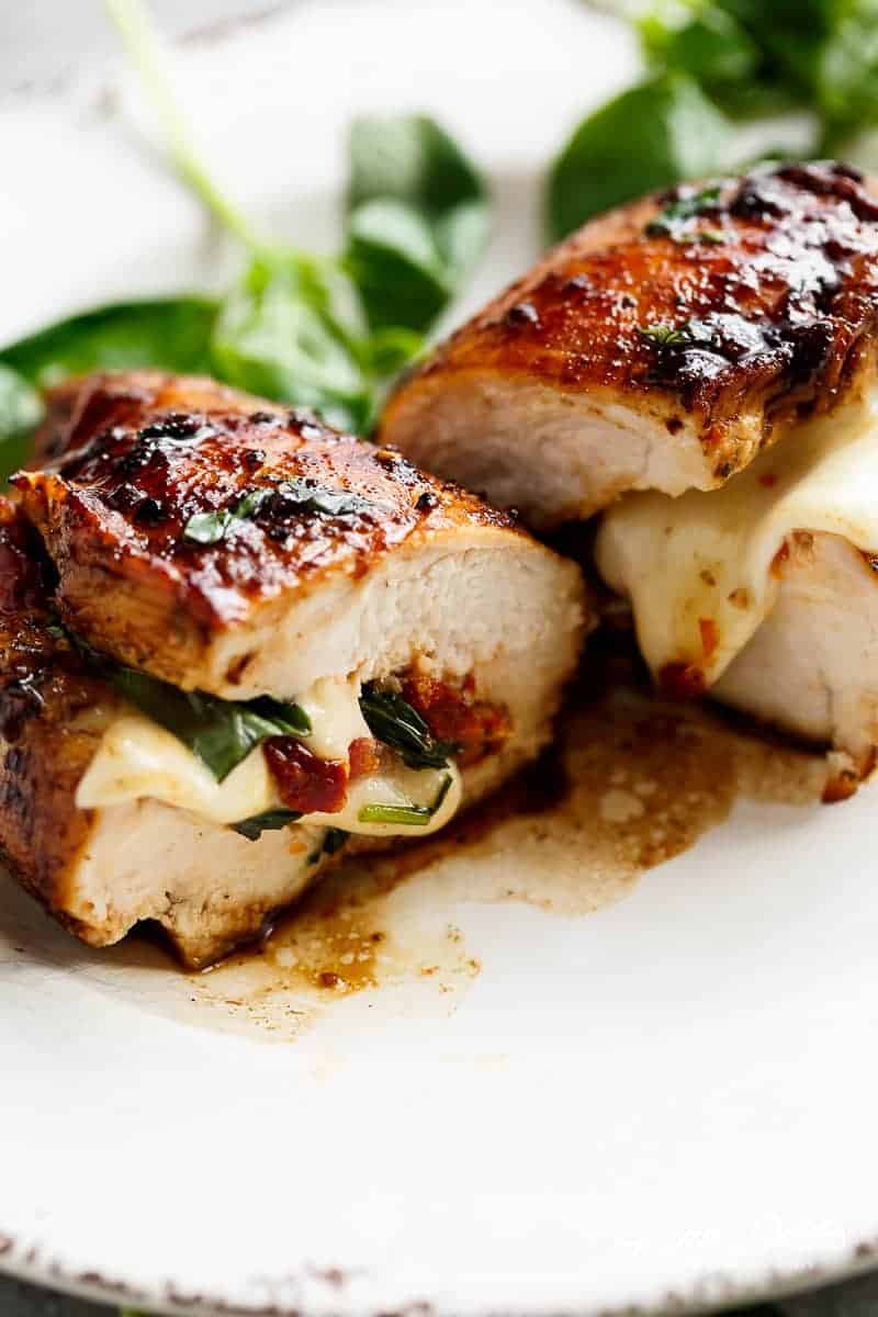 Caprese Stuffed Balsamic Chicken being cut into half on a plate