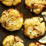 Crispy Greek Lemon Smashed Potatoes are Crispy and golden on the outside, soft and fluffy on the inside kept on a pan