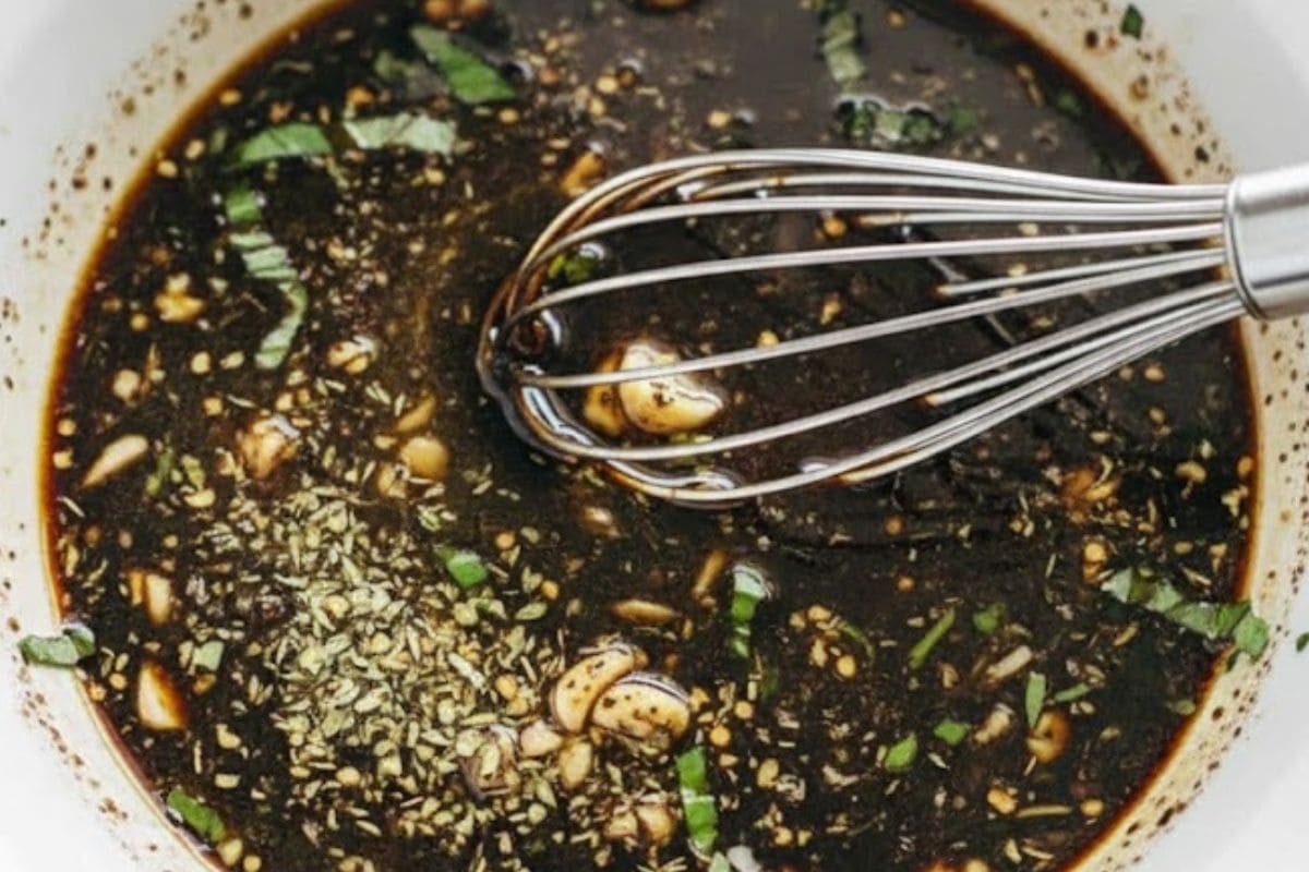 In a large shallow bowl, whisk together olive oil, balsamic vinegar, garlic, oregano, basil, salt, and pepper