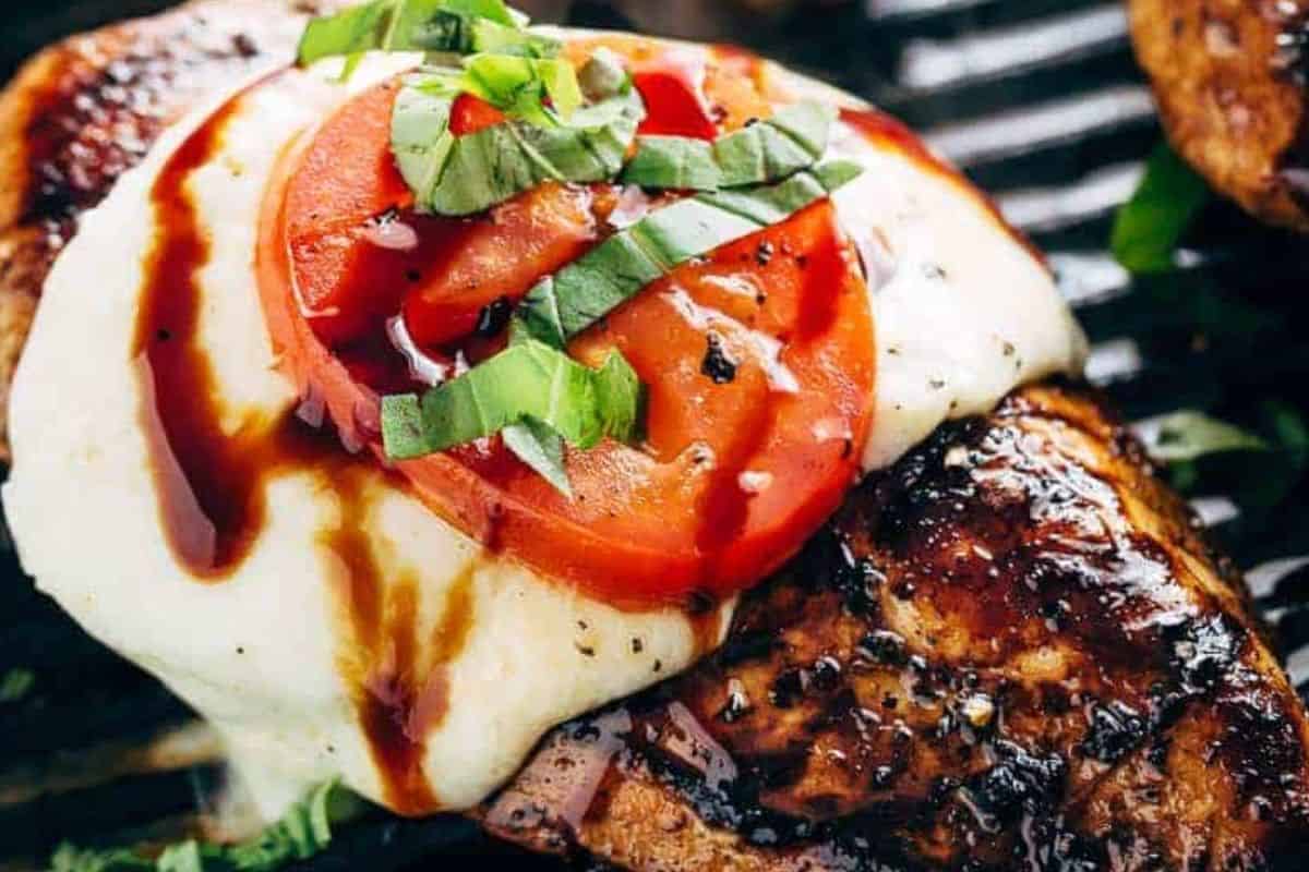 Top each chicken with mozzarella and a tomato. Let the heat melt the cheese, then finish with basil and a drizzle of balsamic reduction.