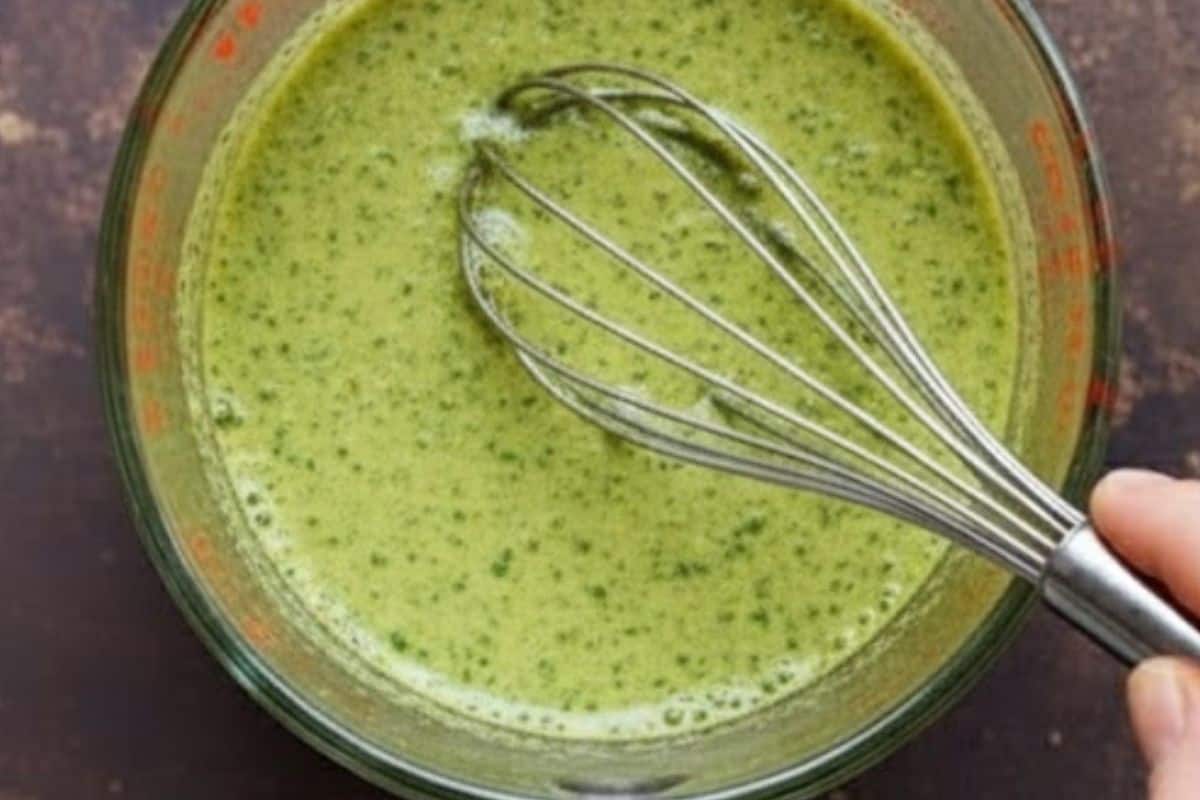 Whisk together olive oil, basil pesto, lemon juice, garlic, salt, and pepper in a large jug until smooth.