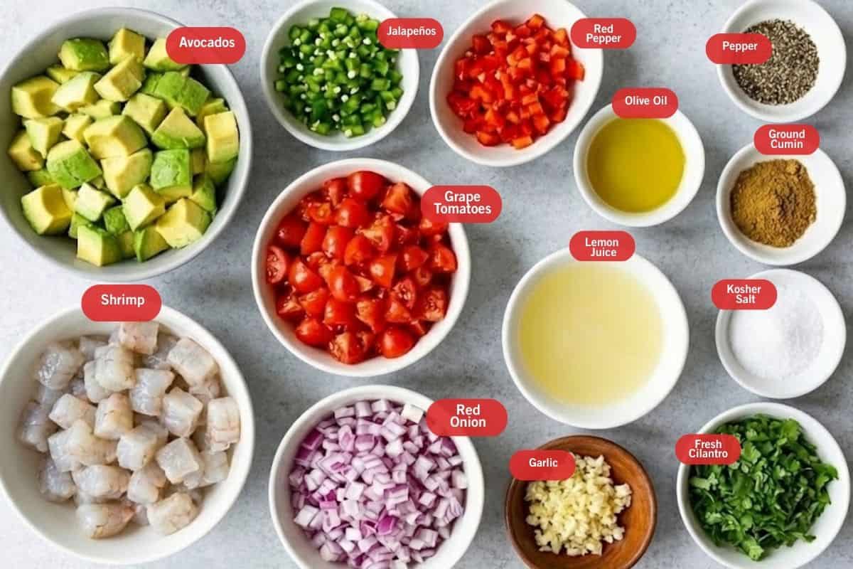 Flat lay photo of ingredient shot of avocados, jalapeños, red pepper, pepper, olive oil, ground cumin, olive oil, kosher salt, fresh cilantro, garlic, red onion, grape tomatoes, shrimp
