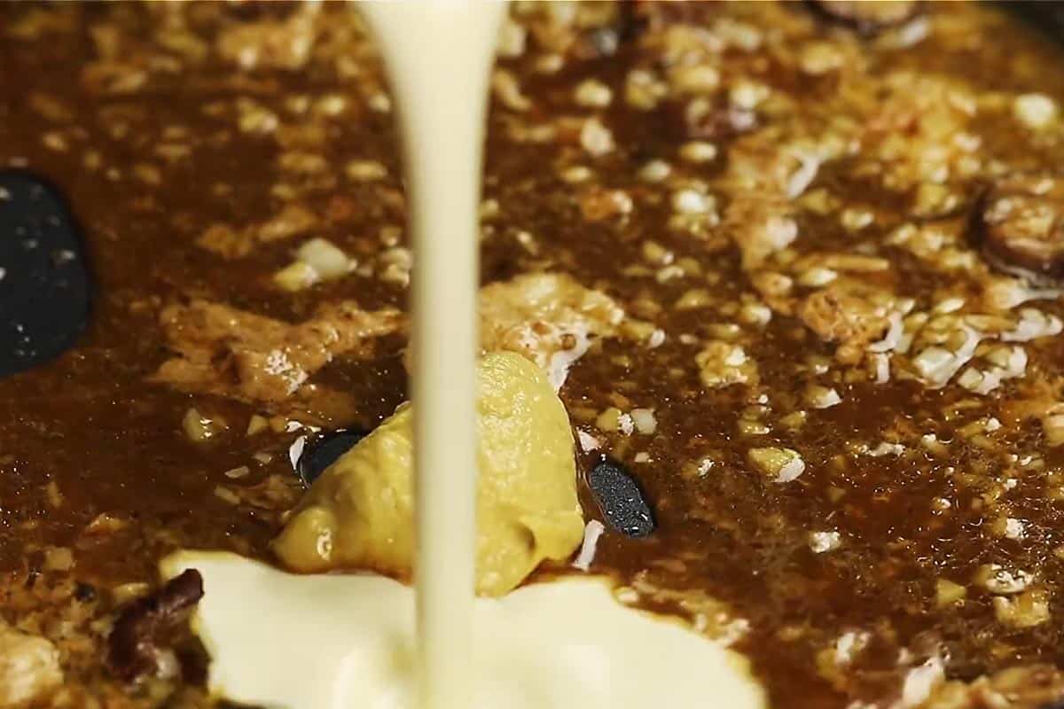 Pouring the cream in the sauce.
