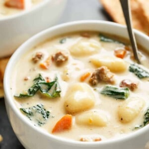 Slow Cooker Creamy Gnocchi Sausage Kale Soup with spinach, sausage, gnocchi and kale poking through the soup in a bowl