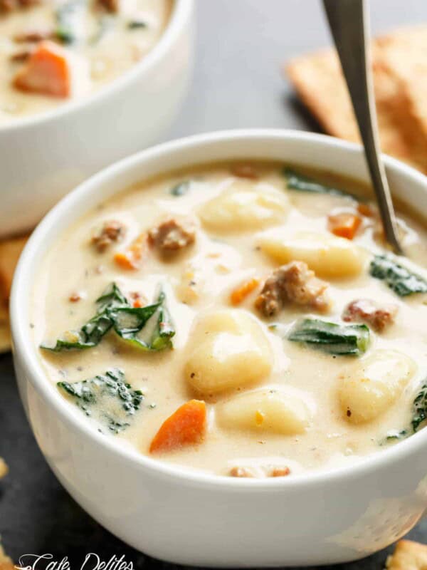 Slow Cooker Creamy Gnocchi Sausage Kale Soup  with spinach, sausage, gnocchi and kale poking through the soup in a bowl