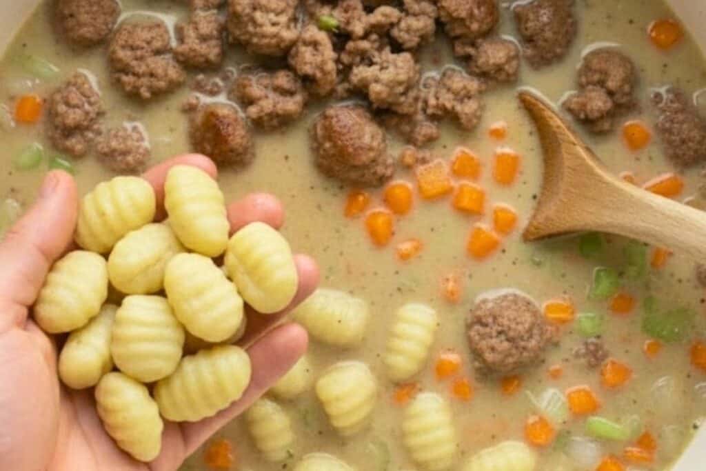 Drop in the fresh gnocchi, give it a quick stir, and cover again. Let it cook for about 30 minutes.