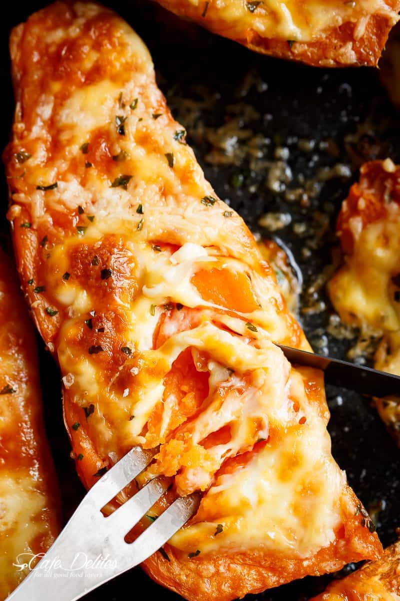 Mozzarella cheese and parmesan top these tender garlic butter smothered sweet potatoes with fork