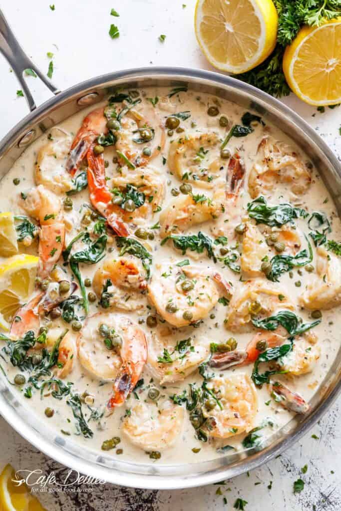 Garlic butter shrimp coated in a rustic creamy garlic parmesan sauce with a hint of lemon, capers and spinach in a pan