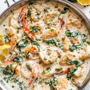 Garlic butter shrimp coated in a rustic creamy garlic parmesan sauce with a hint of lemon, capers and spinach in a pan