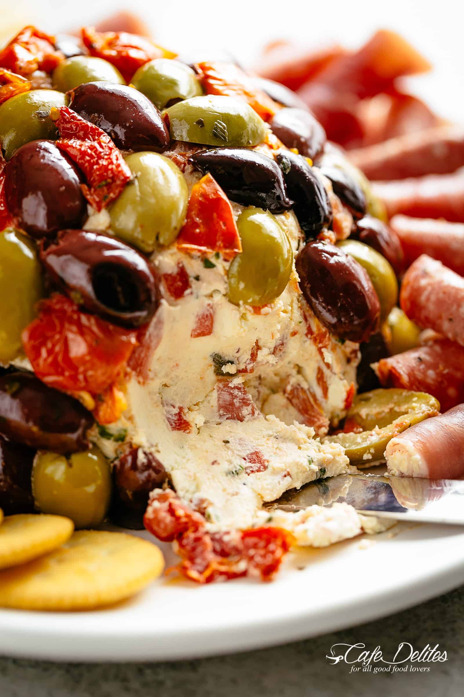 Antipasto Cheese Ball | cafedelites.com A bite taken from Antipasto-Cheeseball on a plate