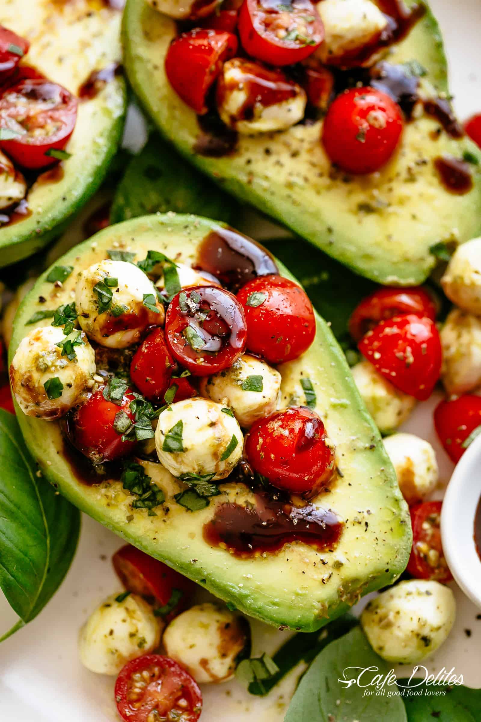 Basil Pesto Caprese Stuffed Avocado drizzled with balsamic glaze make an incredible light lunch or snack! Take creamy avocados to a different level! Sweet and juicy grape/cherry tomatoes with fresh mozzarella balls are tossed through basil pesto and spooned into avocado halves! 