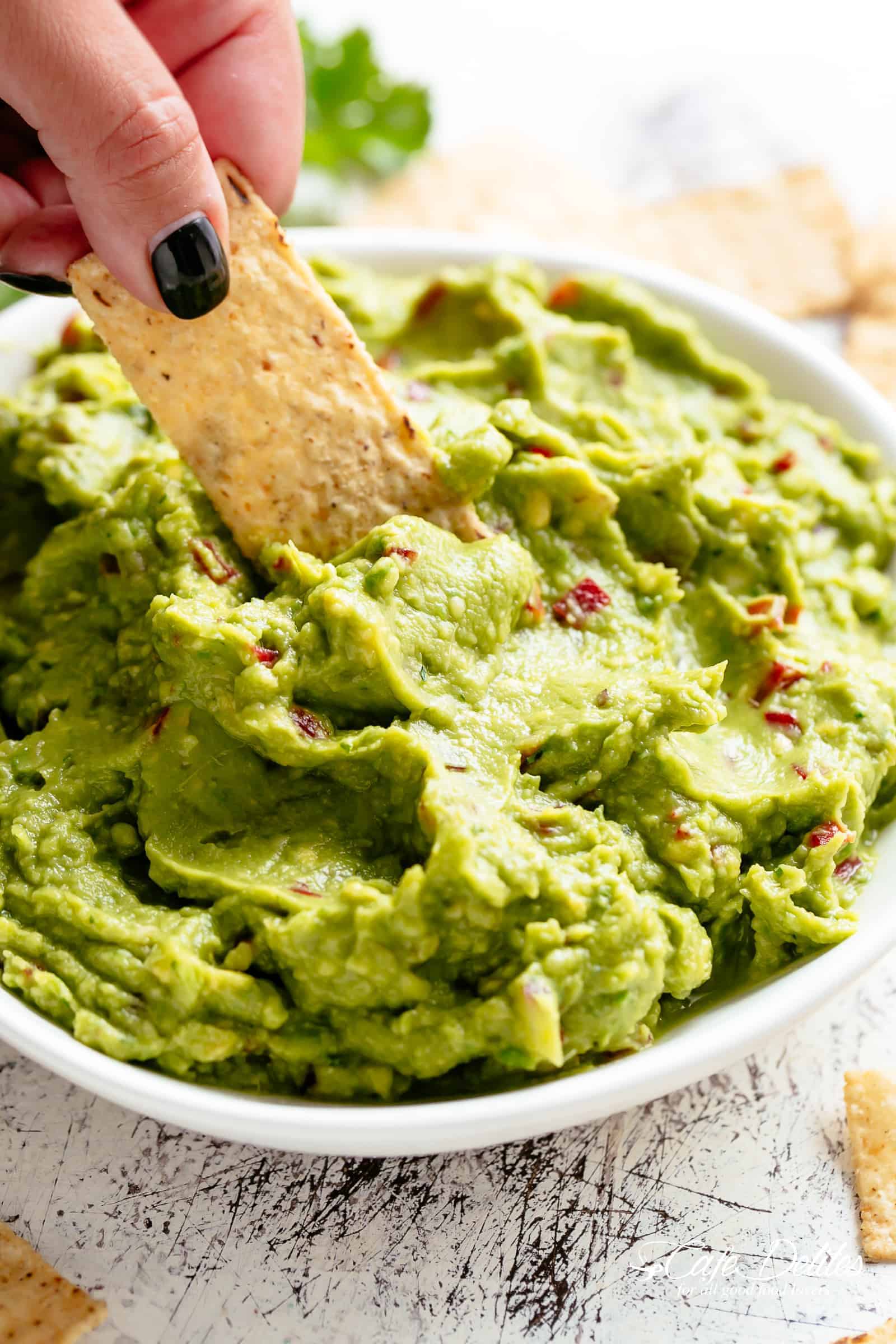Guacamole is perfect for a party as an appetizer OR snack! | cafedelites.com Homemade Guacamole for fajitas, tacos and carnitas in a white bowl