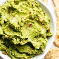 Top view of The best, creamy Guacamole is so easy to make and better than anything found in a jar! Homemade Guacamole takes minutes to make and is so incredibly delicious! Perfect for a party as an appetizer OR just a simple snack! Use as a topping for your favourite fajitas, tacos and even carnitas.