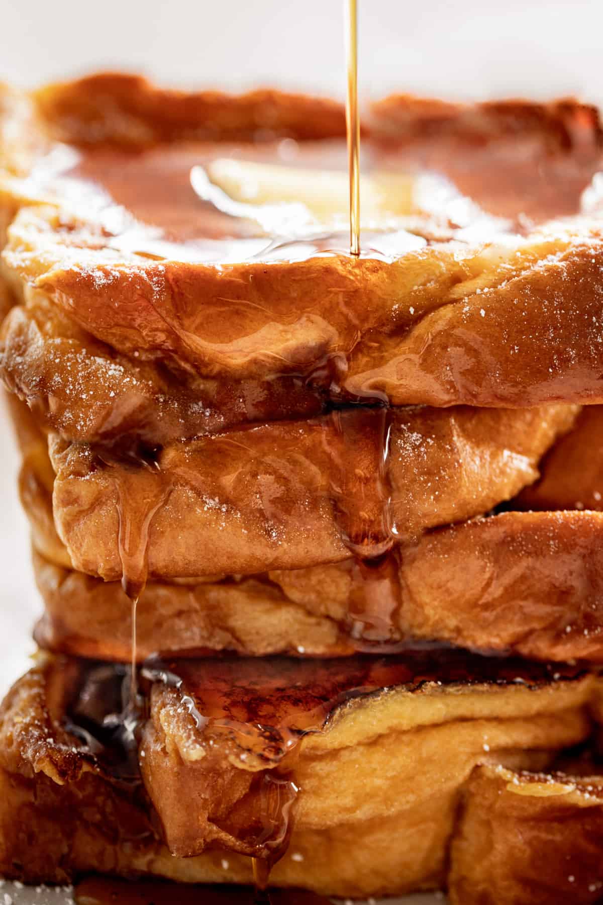 Side view image of The Best French Toast drizzled with maple syrup.