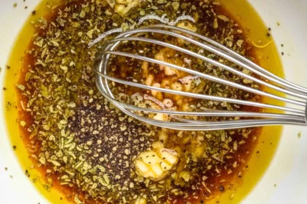 In a medium bowl, whisk together the olive oil, red wine vinegar, garlic, oregano, salt and pepper