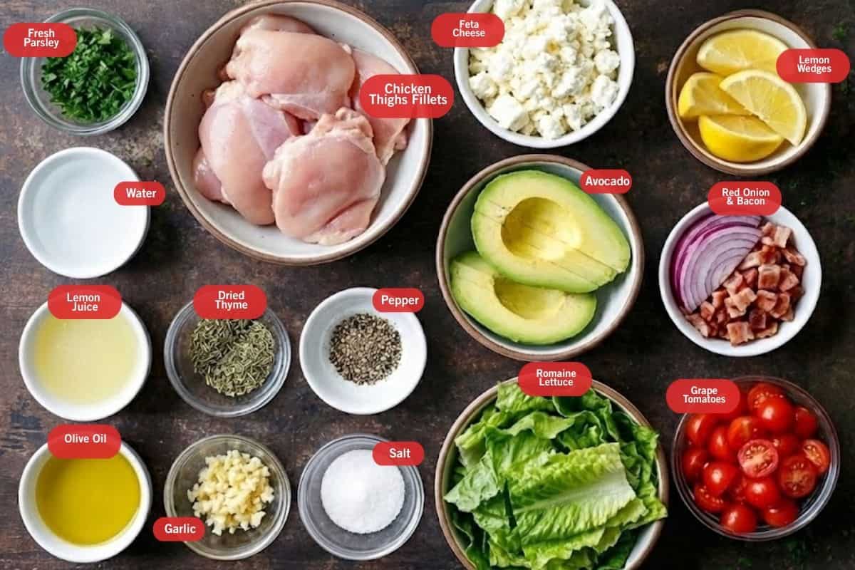 Flat lay photo of ingredient shot of fresh parsley, chicken thighs fillet, feta cheese, lemon wedges, red onion and bacon, grape tomatoes, romaine lettuce, salt, pepper, garlic, dried thyme, olive oil, lemon juice, water