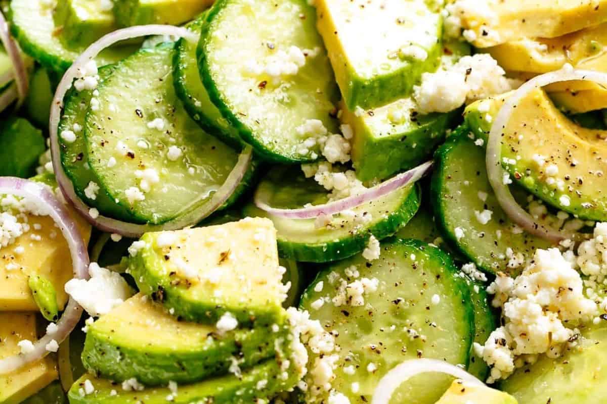 Add the cucumber slices, avocado, feta and onion slices into the dressing and toss well.