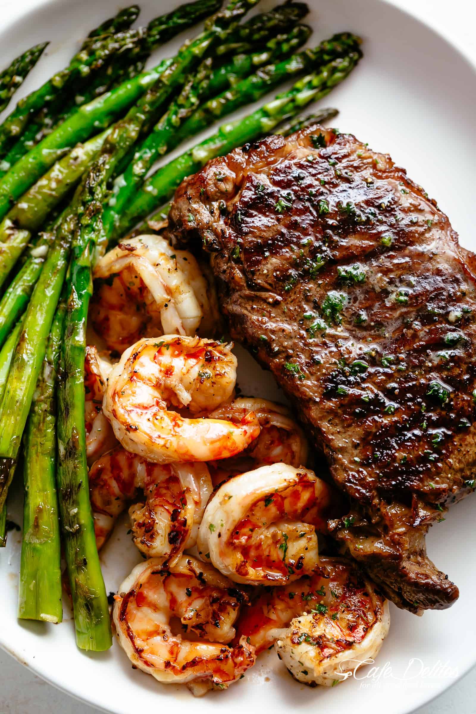 Steak & Shrimp slathered in garlic butter makes for the BEST steak recipe! | cafedelites.com Grilled Steak & Shrimp on a plate