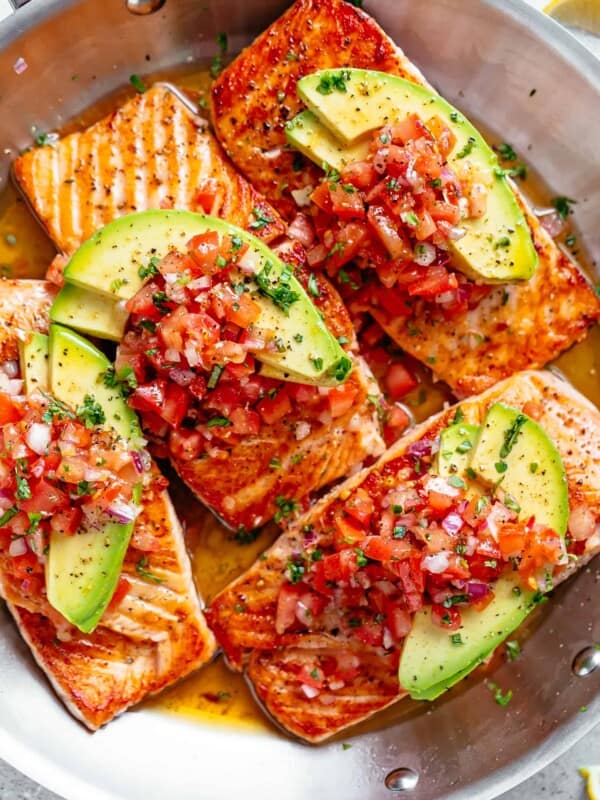 Pan Seared Salmon in a buttery garlic lemon sauce, topped with a fresh tomato salsa and avocado slices