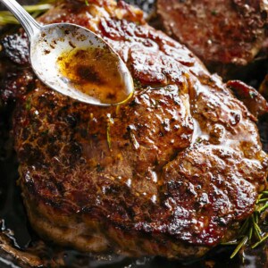 Butter garlic mixture being poured on Basted Steak