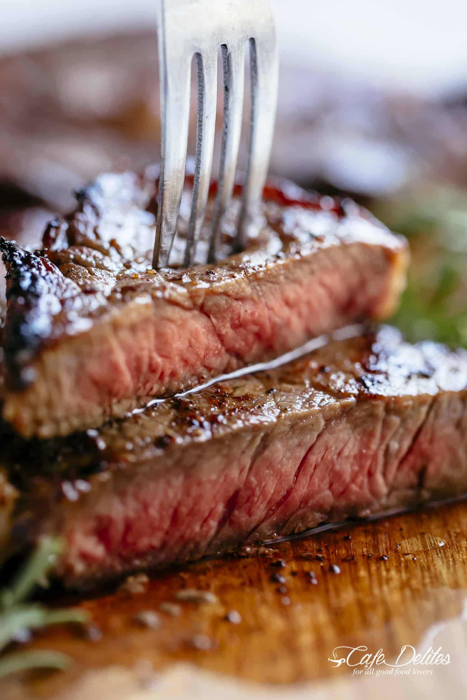 A fork pierced into a piece of Medium Rare Steak