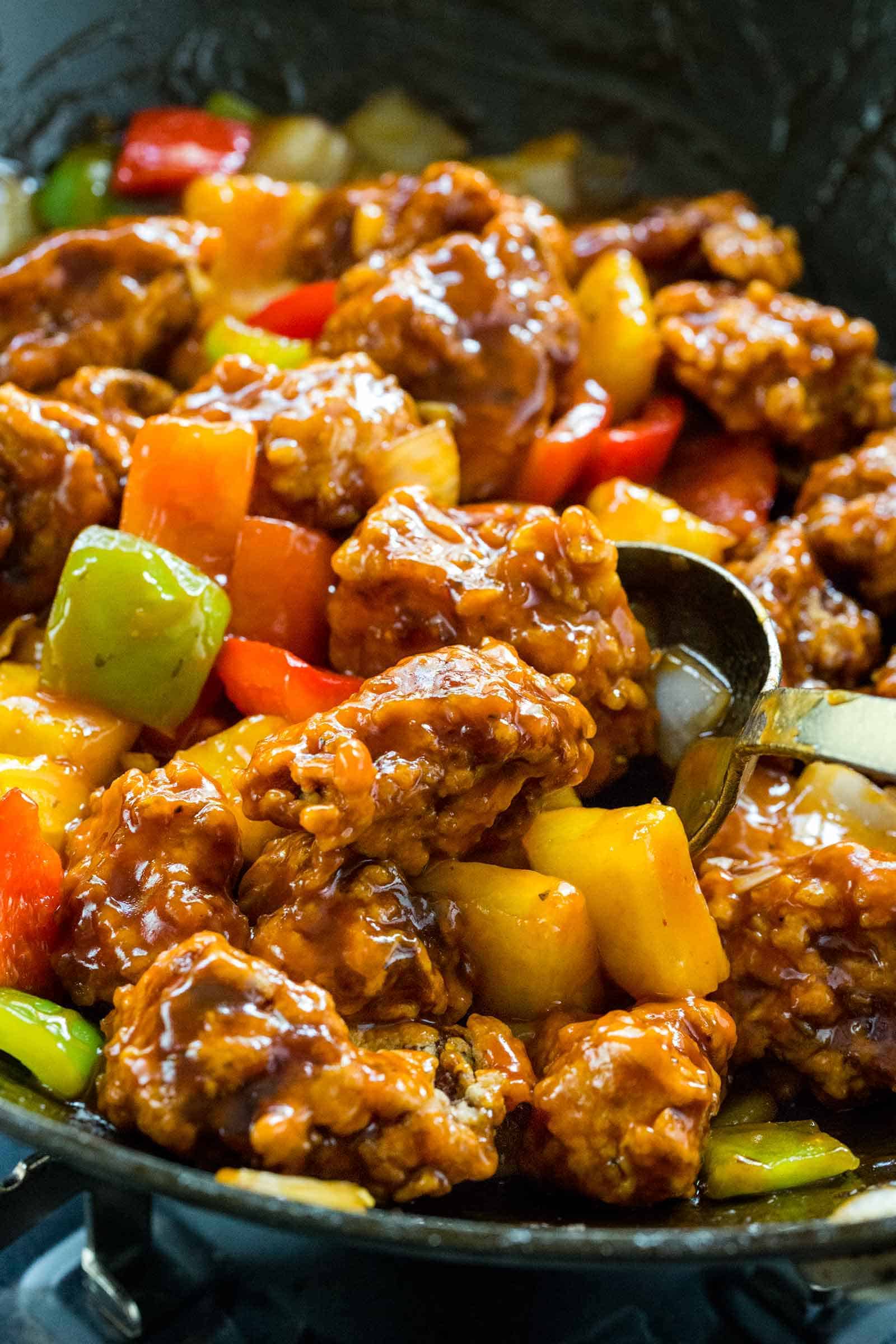homemade sweet and sour pork cooking in a wok in a bowl