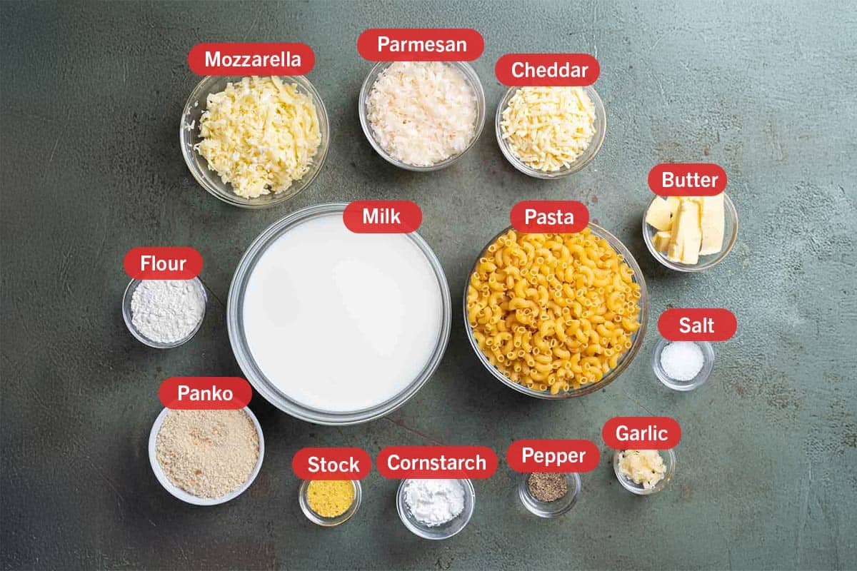 image with all the ingredients needed for the creation of this recipe, specifically: milk, pasta, salt, garlic, pepper, cornstarch, stock, panko, flour, mozzarella, parmesan, cheddar, and butter.