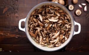 Mushrooms and thyme being added to the pot