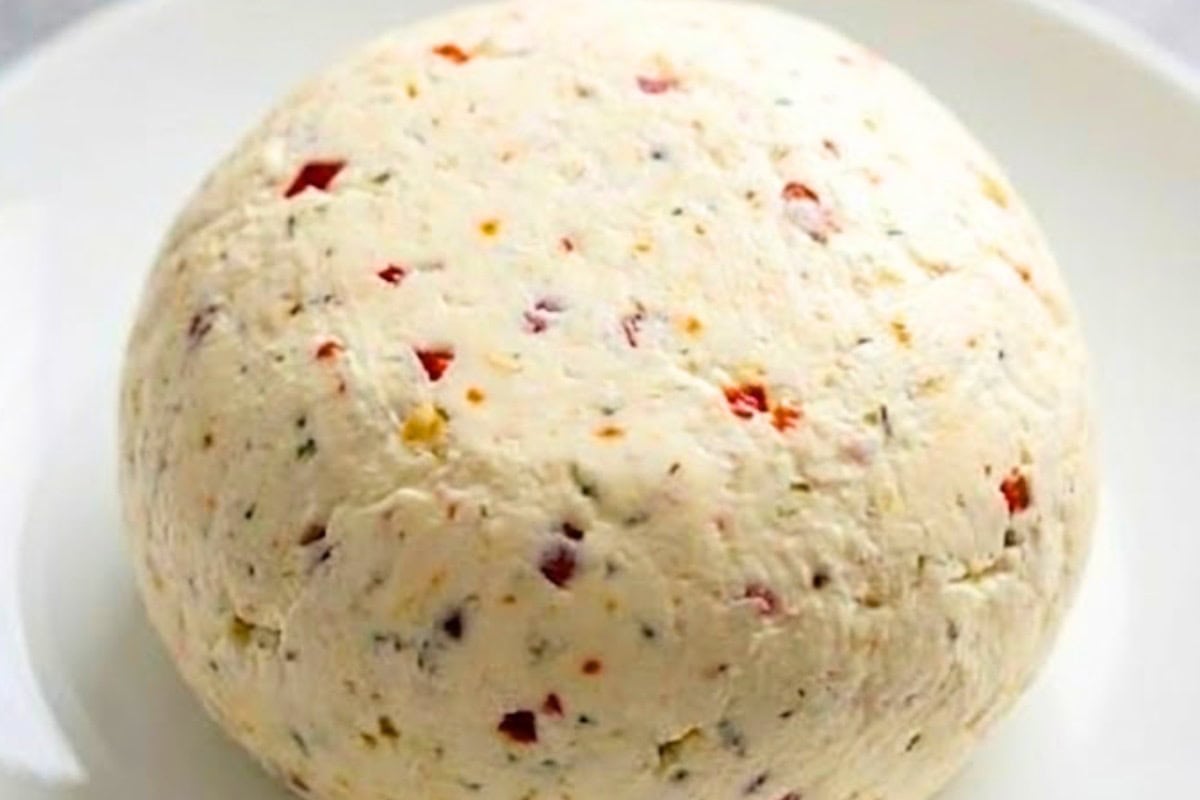 Using your hands, mould the wrapped mixture into a ball. Peel away the bottom layer of plastic wrap and place the cheese ball onto a serving plate.