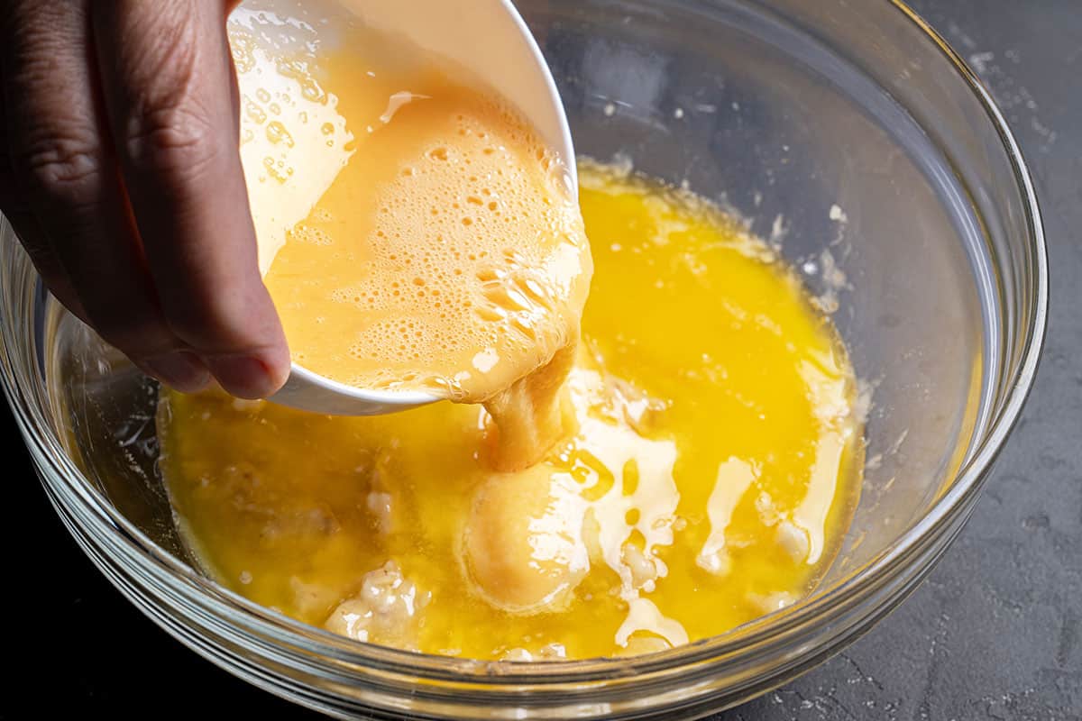 egg mixutre being poured into dry mixed piece