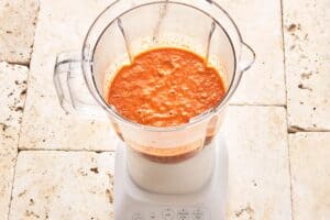 Image of the sauce, previously sautéed in a skillet, being blended in a blender for a velvety and creamy texture.