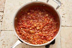 Preparation of the sauce with spices, butter, and onions being sautéed in a skillet.