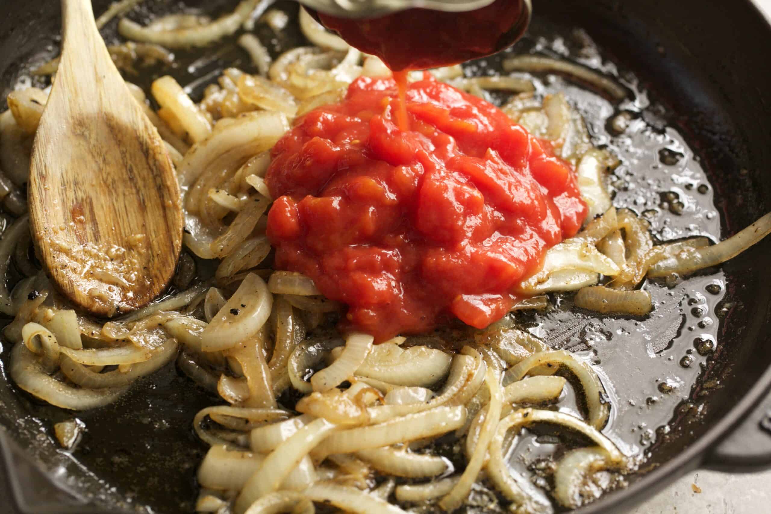 onion and crushed tomatoes in a pan