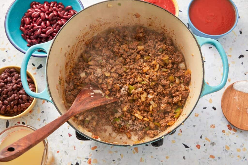 Cooking the beef in a pot with aromatics and seasoning