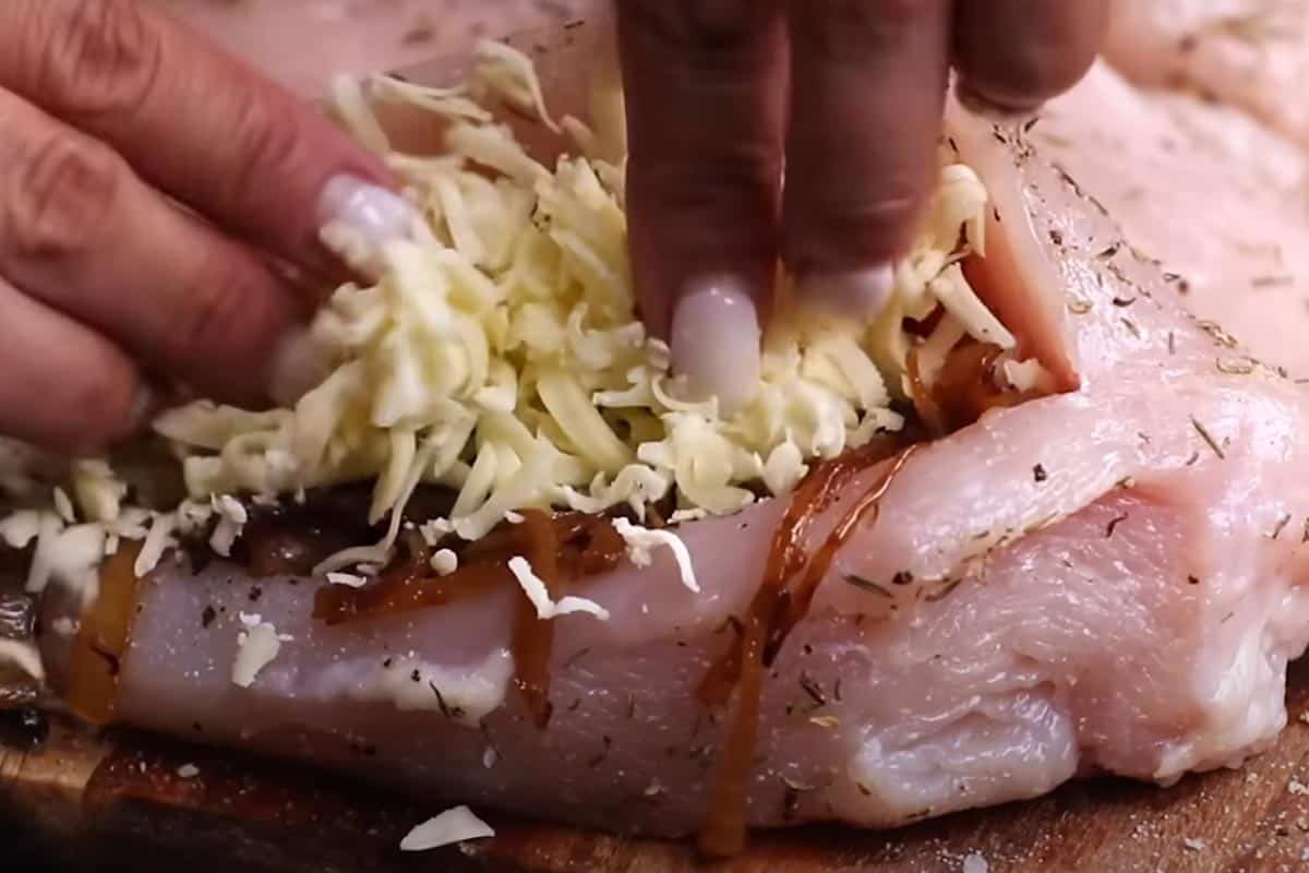Filling the chicken with caramelized onions and mix of gruyere and parmesan cheese.