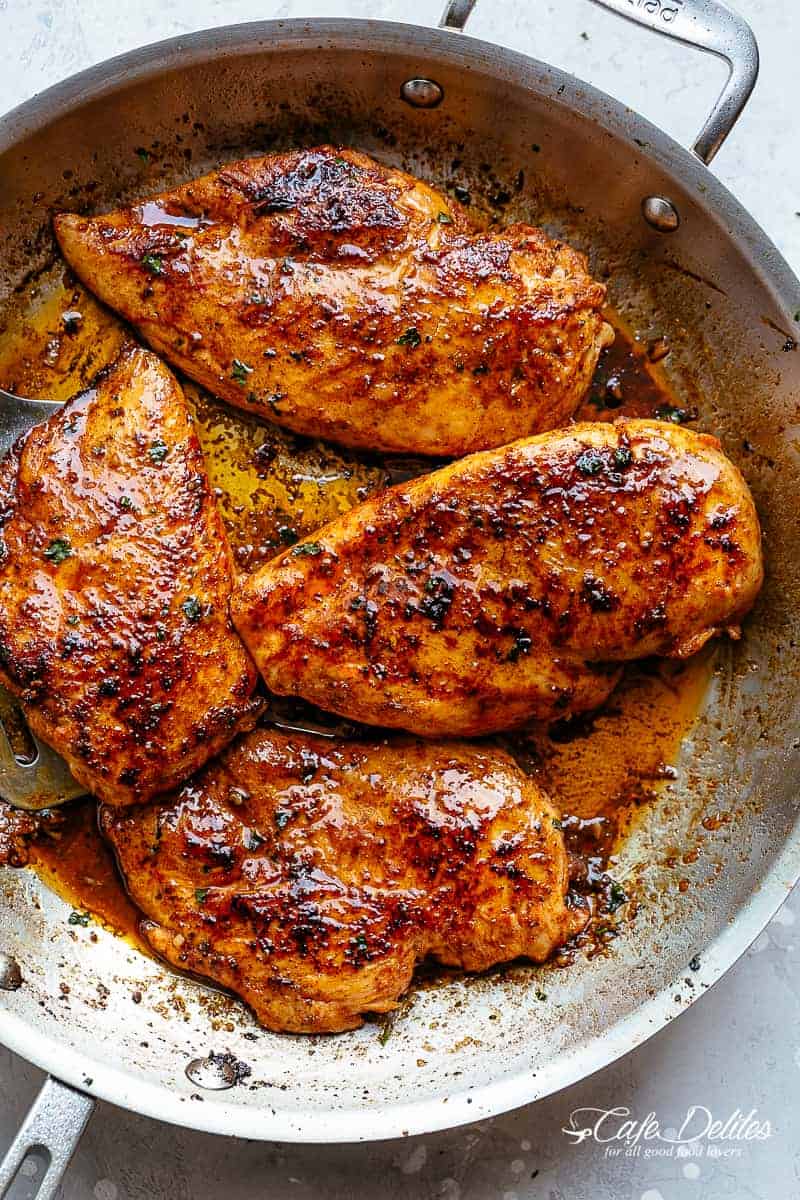 Four Spicy Cajun butter chicken breast pieces, slightly charred in a silver pan.