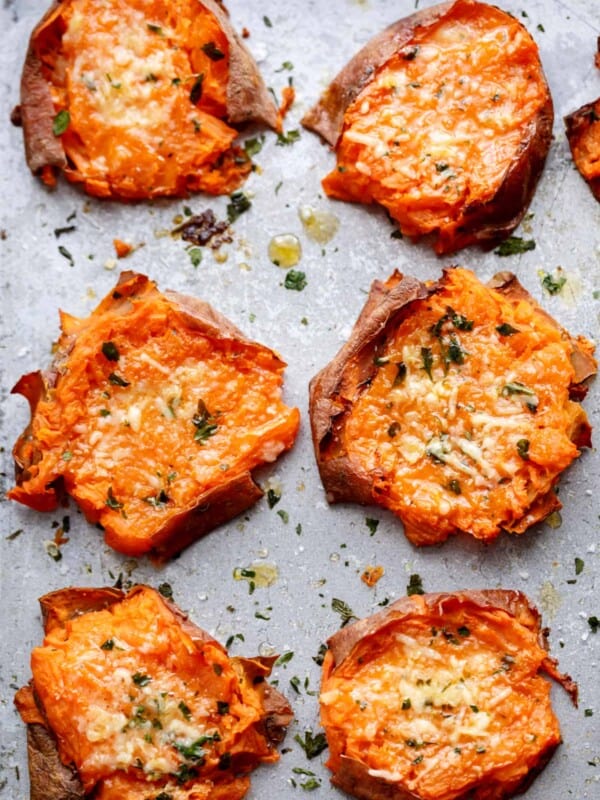 Pieces of Garlic Butter Smashed Sweet Potatoes With Parmesan kept on baking paper