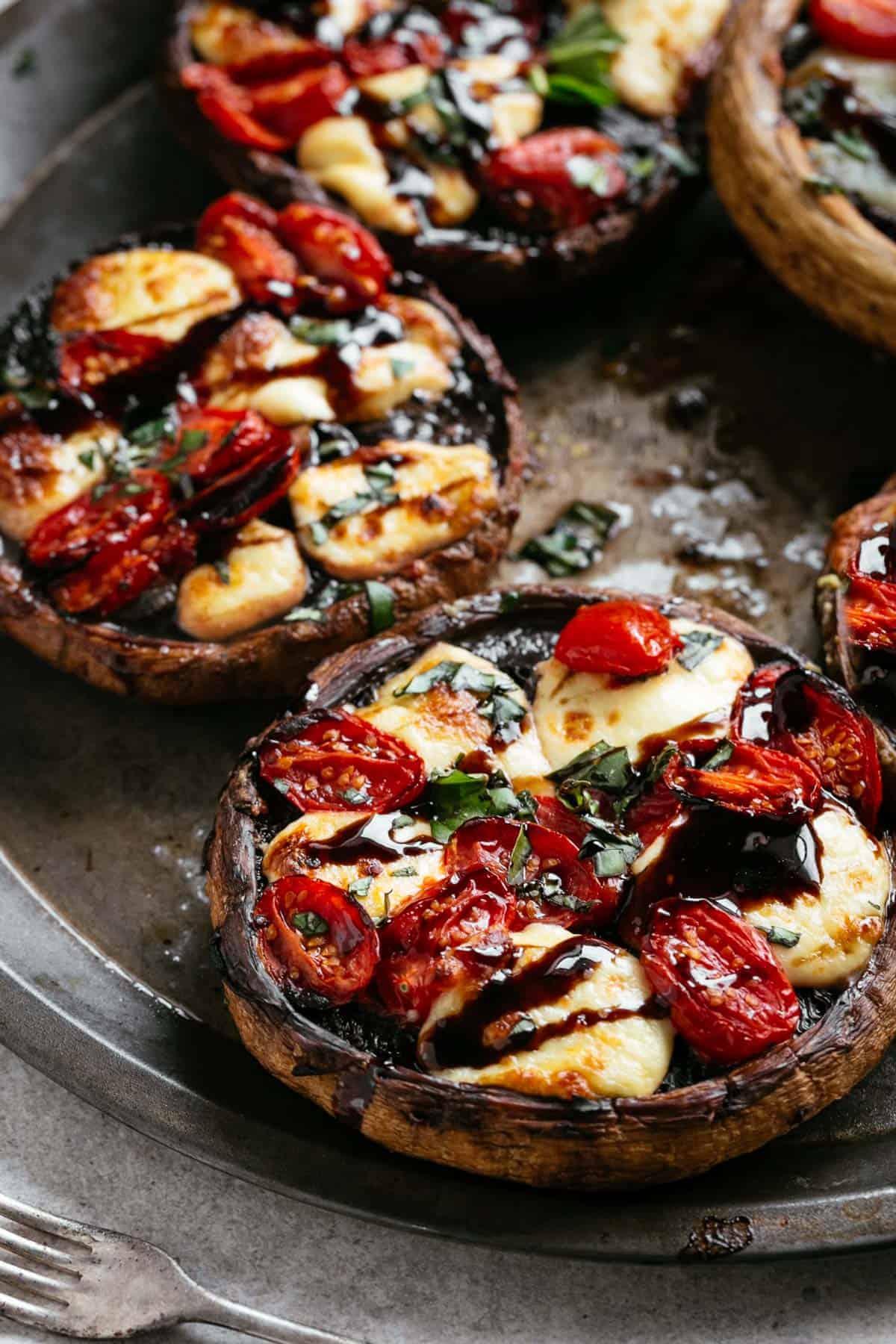 2 pieces of Caprese Stuffed Portobello Mushrooms on a plate. 