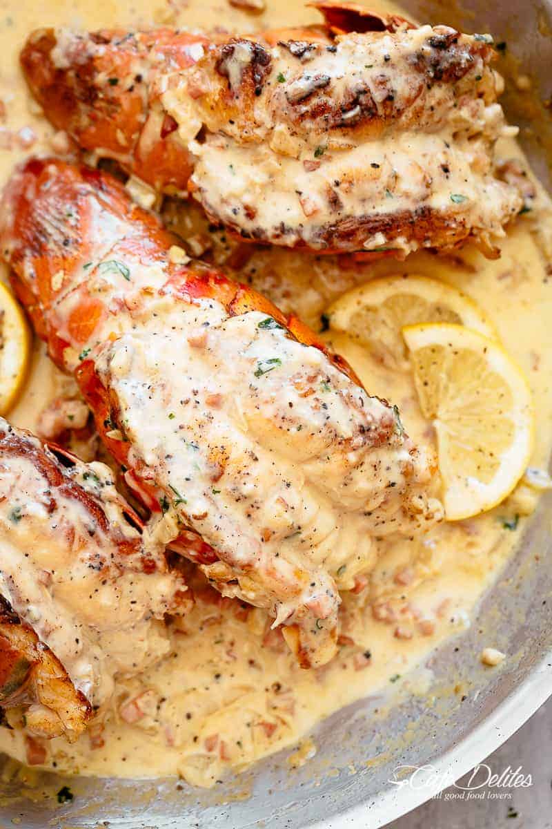 Lobster tails with a creamy bacon sauce and lemon wedges
