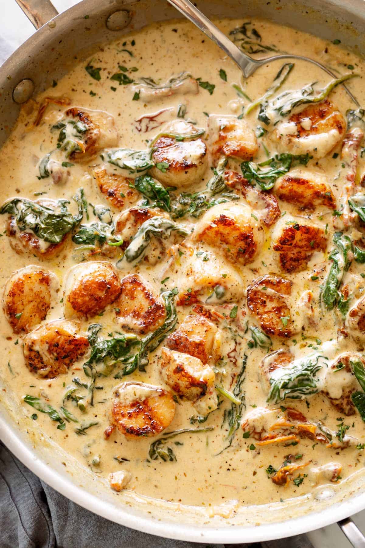 Garlic Butter Creamy Tuscan Scallops in a buttery cream sauce filled with garlic, spinach, sun dried tomatoes and parmesan cheese!