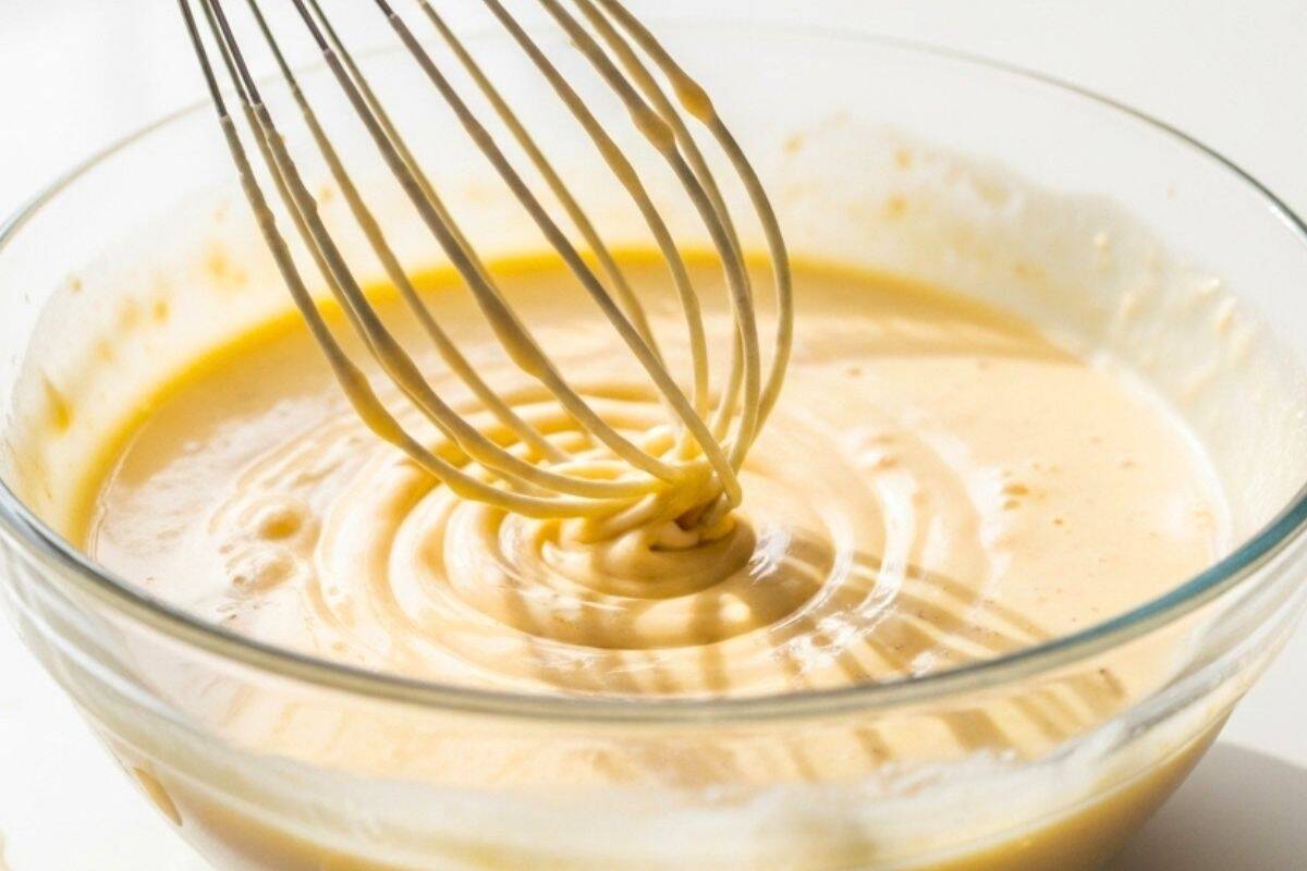 Slowly whisk in the milk mixture, about ½ cup at a time, into the egg yolks to avoid scrambling and pour the rum until smooth