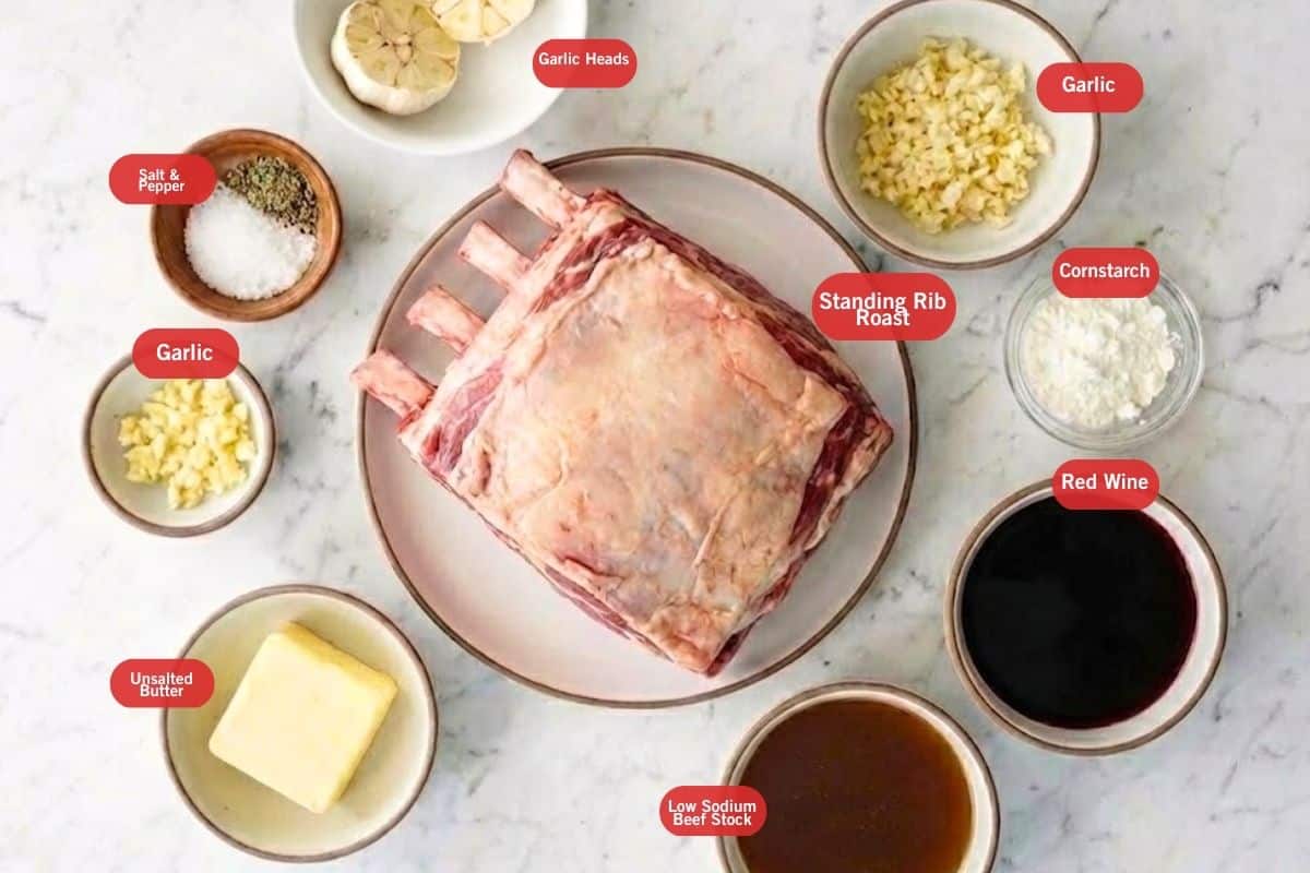 Flat lay of standing rib roast, head garlic, unsalted butter, garlic, salt and pepper, low sodium beed stock, red wine, cornstarch