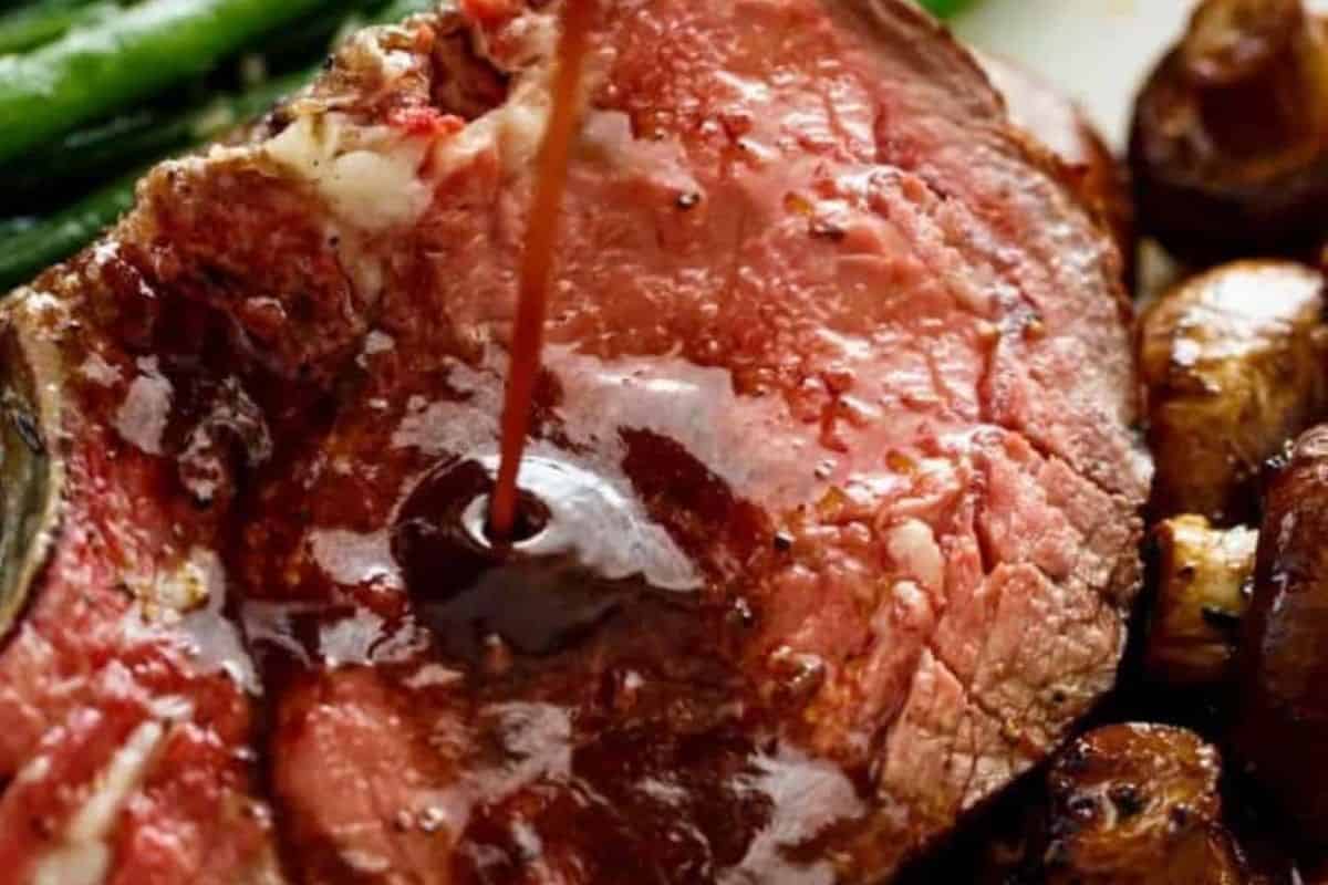 Place the pan with drippings and garlic halves on the stove. Add wine and 2½ cups beef stock, then stir in a cornstarch slurry made with the remaining stock. Simmer until thickened and strain.