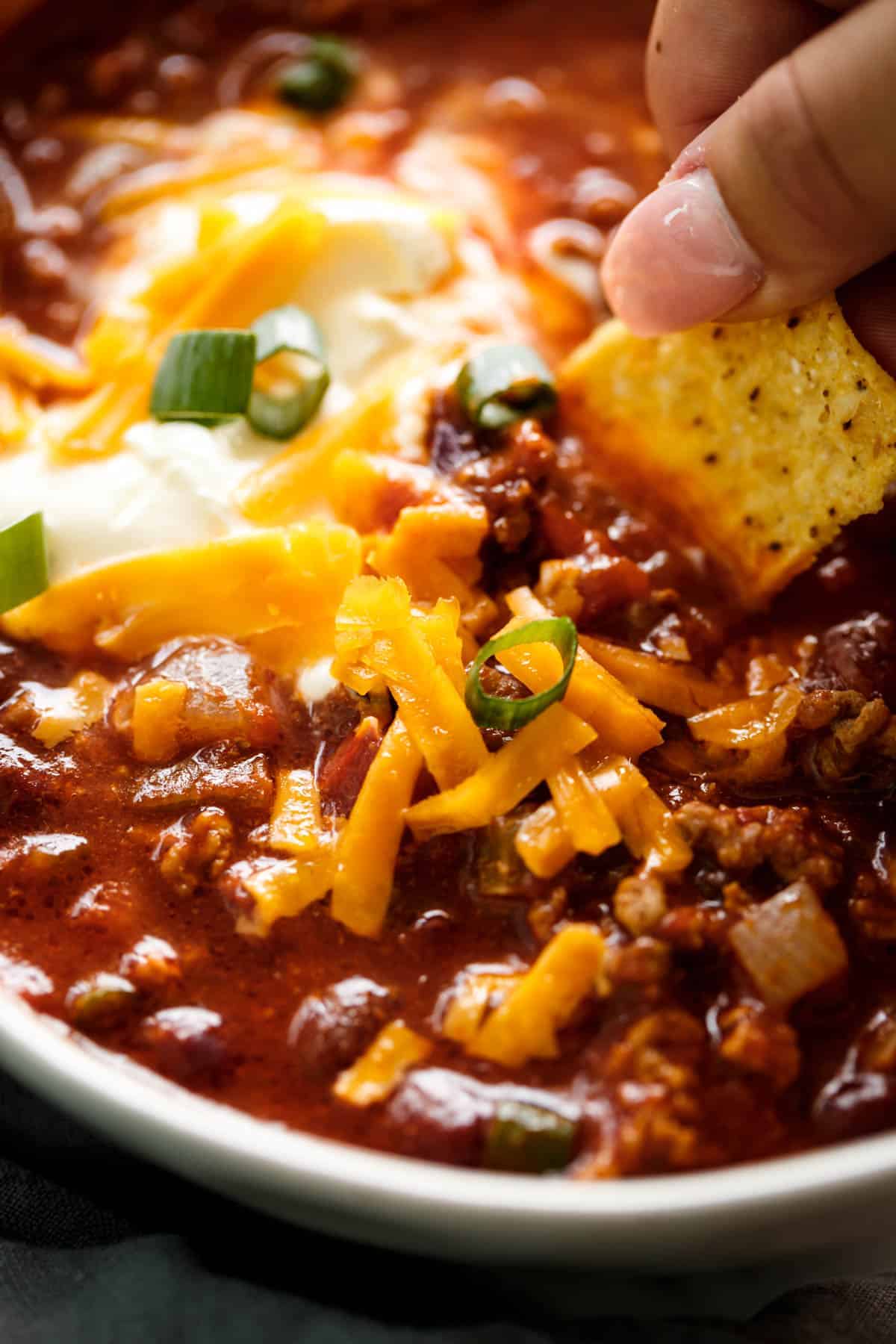 Yummy sloe cooker chili with nacho in white bowl